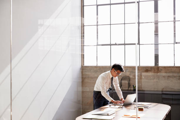istock Businessman working alone in a office, seen through window 1010835826