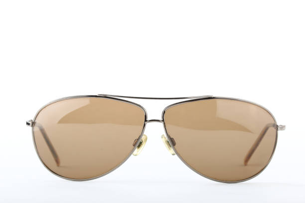 istock Single scratched old classic sunglasses with metal frame and brown lenses on a white background 1010835848