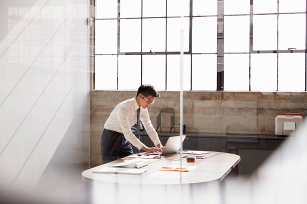 Businessman working alone in a office, seen through window