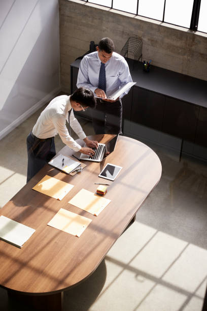 istock Two businessmen stand working at a desk in an office 1010835908