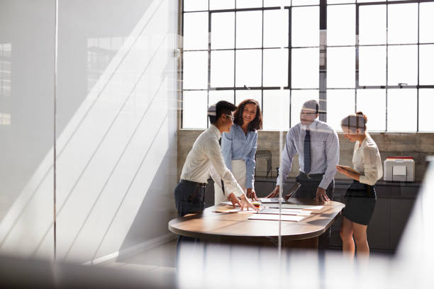 istock Business team seen through window working together in office 1010836042