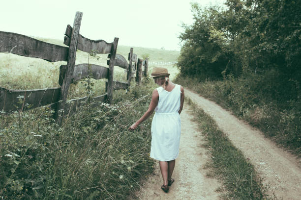 istock Woman walking alone on dirt road 1010836058