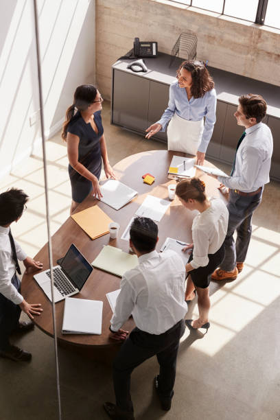 Female manager in team meeting, elevated view through window