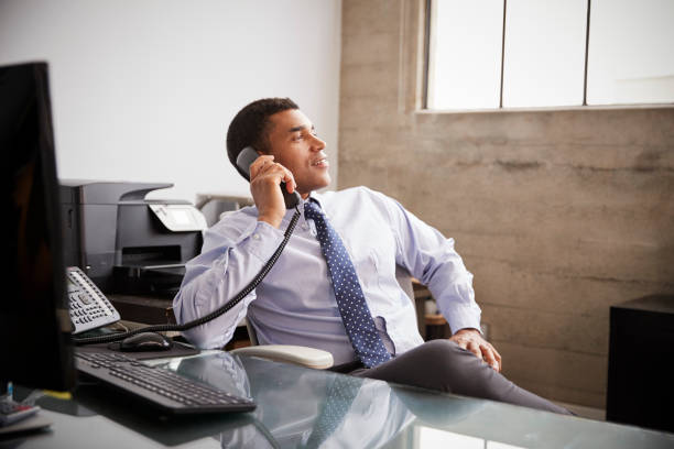 istock Mixed race businessman at an office desk using the phone 1010837036