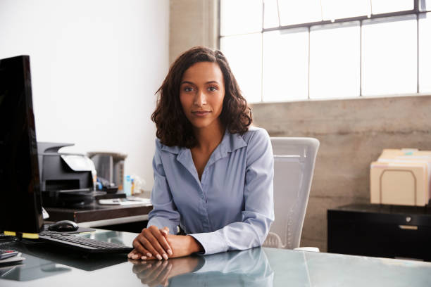 istock Young mixed race woman at office desk looking to camera 1010837126
