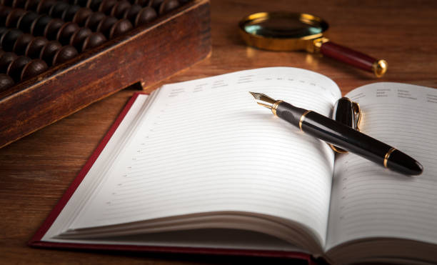 istock fountain pen and diary on a table with an abacus and loupe close up 1010837310