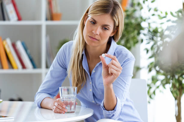 istock Depressed young woman taking pills at home. 1010841934