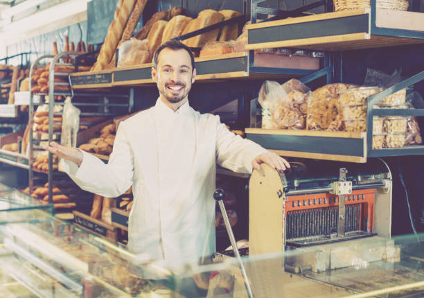 istock Man seller displaying assortment of bakery 1010843232