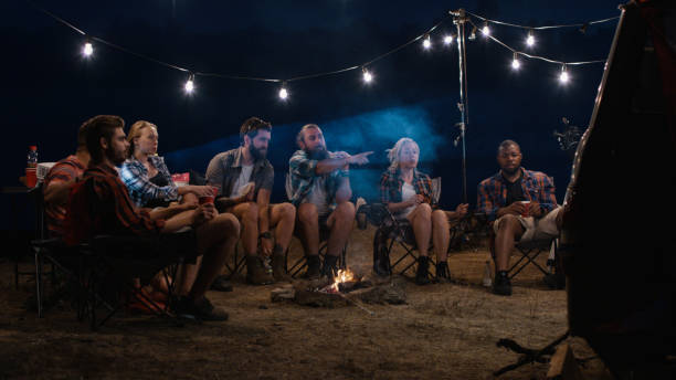 istock Young people watching movies near campfire 1010847982