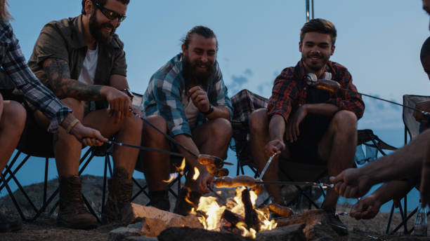 istock Friends frying sausages on campfire in twilight 1010850430