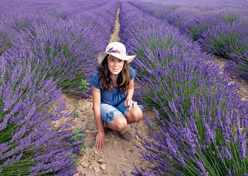 Young teen girl in a lavender fiel at full blossom, in Provence.