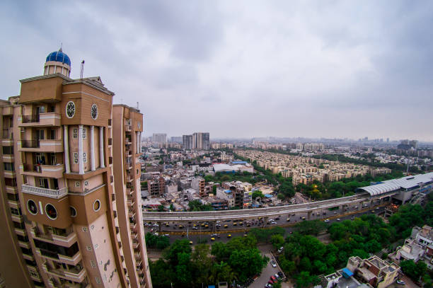 Noida gurgaon cityscape at blue hour with skyscrpaers, buildings, homes, residences, metro bridge, busy street with light trails and building stretching far into the distance. Shows the city in all it's glory
