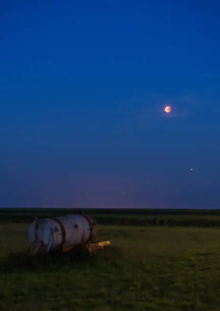 The July 2018 Bloodmoon (lunar eclipse) seen above a meadow on Schiermonnikoog, a dutch Island. You can also see Mars just a bit below.