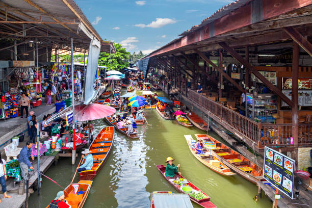 Floating Market in Damnoen Saduak, Thailand Damnoen Saduak, Thailand - June 19, 2018: Floating market with fruits, vegetables and different items sold from small boats, in Damnoen Saduak, Thailand ratchaburi province stock pictures, royalty-free photos & images