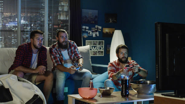 istock Group of men play videogame together in evening 1010884430