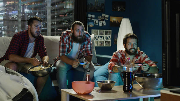 istock Group of men play videogame together in evening 1010884488