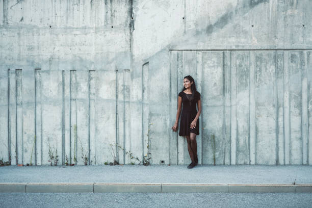 istock Young smiling woman in front of concrete wall 1010887918