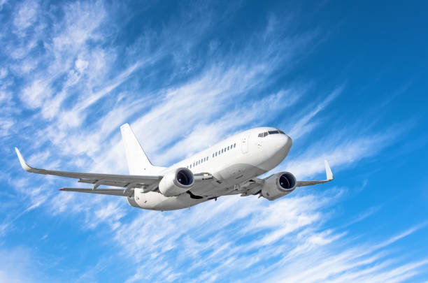 istock Flying passengers aircraft fly climb on a background of blue sky and cirrus clouds. 1010889794