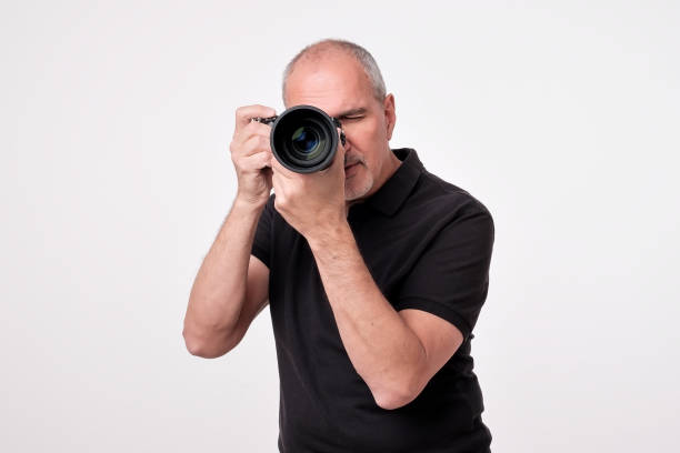 istock Studio shot of young multi-ethnic Asian man with camera against brown background 1010893786