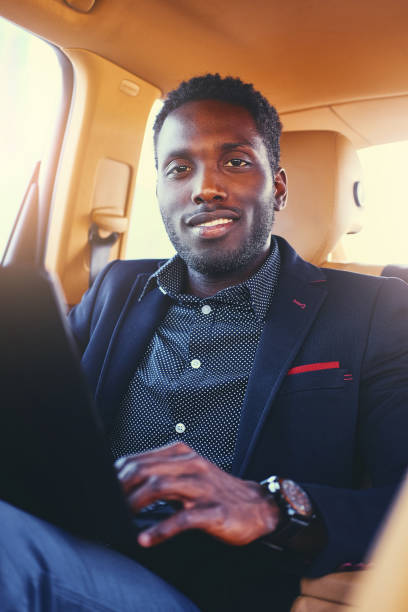 istock Stylish Black male in a car using a laptop. 1010907462