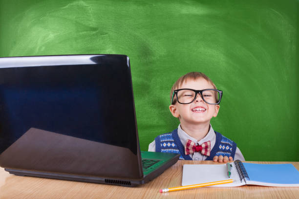 istock Child with laptop peeking in the classroom 1010938044