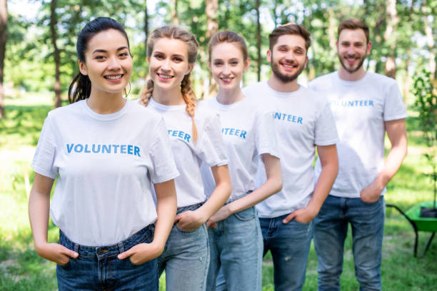 istock young smiling volunteers standing in row in park 1010948716