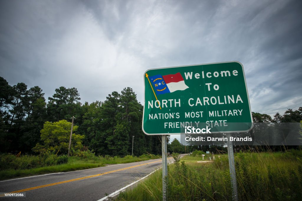 "Welcome to North Carolina" Sign A sign on a two-lane country road welcomes residents and visitors to North Carolina. Camp Lejeune Stock Photo