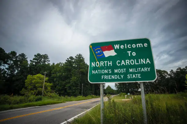 A sign on a two-lane country road welcomes residents and visitors to North Carolina.