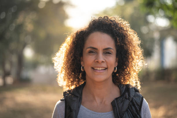 mulher madura linda cabelo encaracolado olhando para a câmera - adult caucasian curly hair human face - fotografias e filmes do acervo