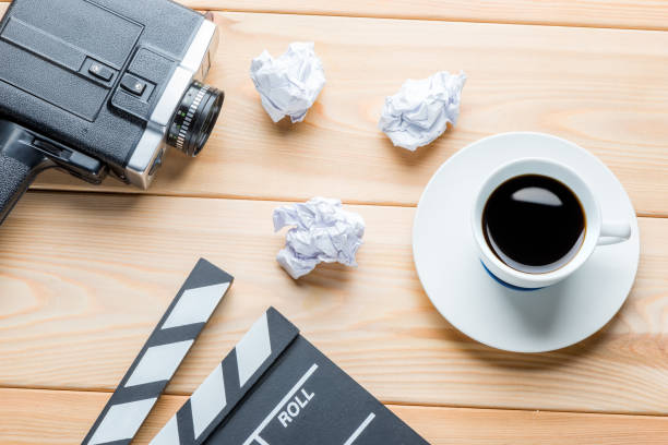 istock film industry - objects on wooden boards top view - clapper, camera and crumpled script sheets 1010980382