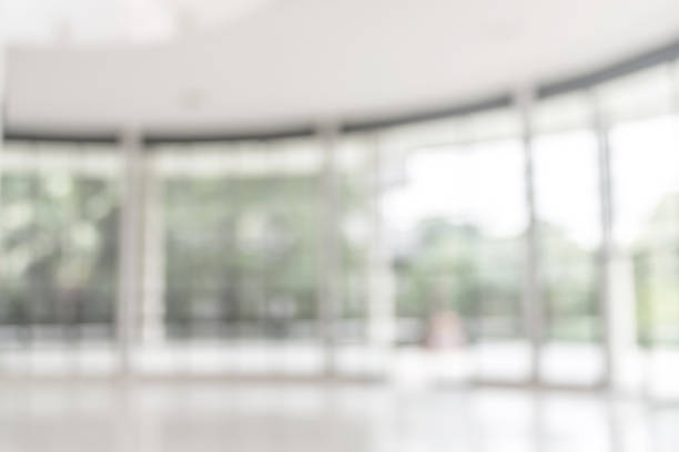 istock Blur background interior view looking out toward to empty office lobby and entrance doors and glass curtain wall 1010980772