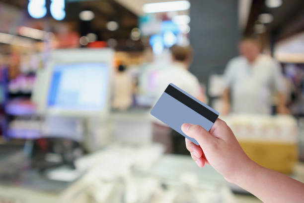 ręka trzymać kartę kredytową z supermarketu kasy z klienta defocused rozmycie tła - cash register paying checkout counter cashier zdjęcia i obrazy z banku zdjęć