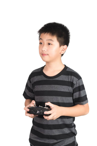istock Asian boy holding radio remote control handset for helicopter, drone or plane, isolated on white background. 1010984194