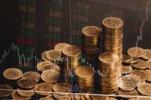 istock Double exposure of coin stack with stock market screen chart board and candle stick for financial business and investor analysis concept idea. 1010984300