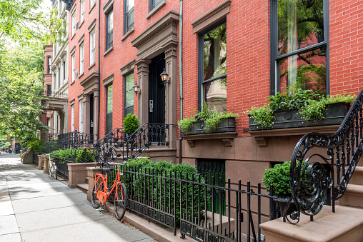 Two bicycles in front of a brownstone building in neighborhood of Brooklyn Heights, New York