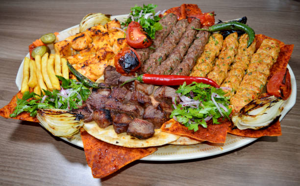 Shish kebab Fast food. Eastern food. Shish kebab, lyulya-kebab, shaverma, pita gyros. Dishes of oriental cuisine lying on pita bread and decorated with greens and vegetables, sauces and French fries. abd stock pictures, royalty-free photos & images