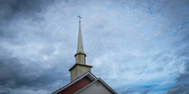 Small Town Church Steeple A weathered church steeple in a small American town. baptist stock pictures, royalty-free photos & images
