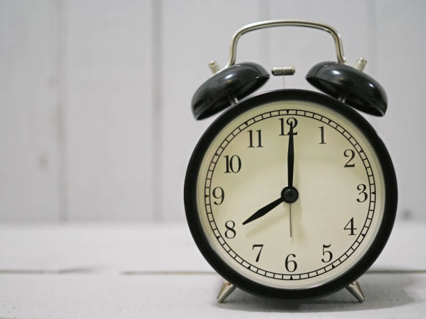 istock alarm clock on white wooden 1011070634