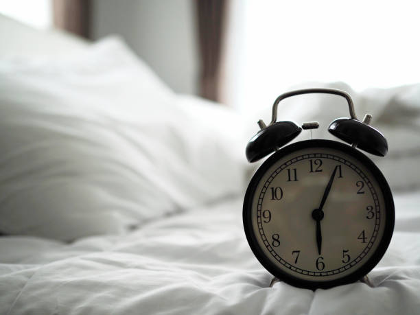 istock Alarm clock on the bed in bed room 1011070790