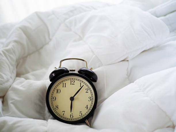 istock Alarm clock on the bed in bed room 1011072900