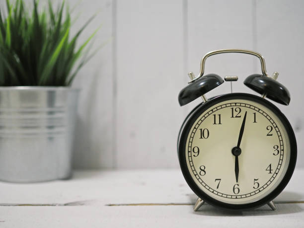 istock alarm clock on white wooden 1011072904