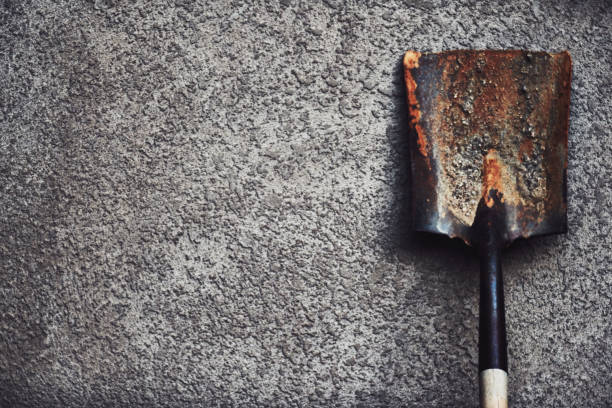Old shovel in front of stucco wall