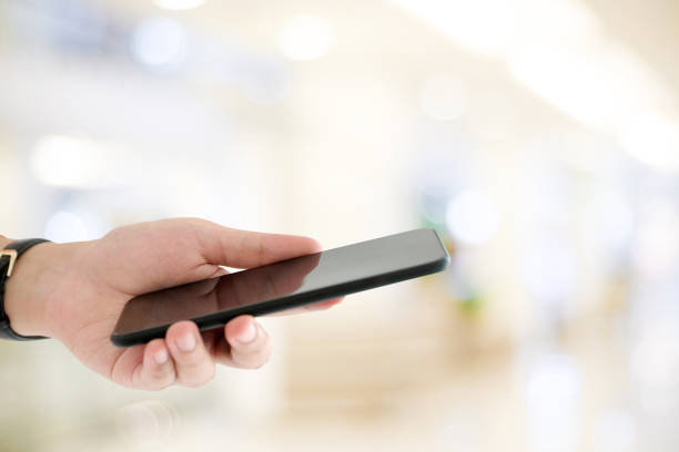 istock Hand using smart phone over blur bokeh light background, business and technology, internet of things concept 1011085652