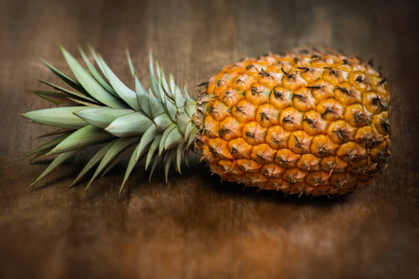 istock Single one full whole organic pineapple fruit on wooden background 1011088750