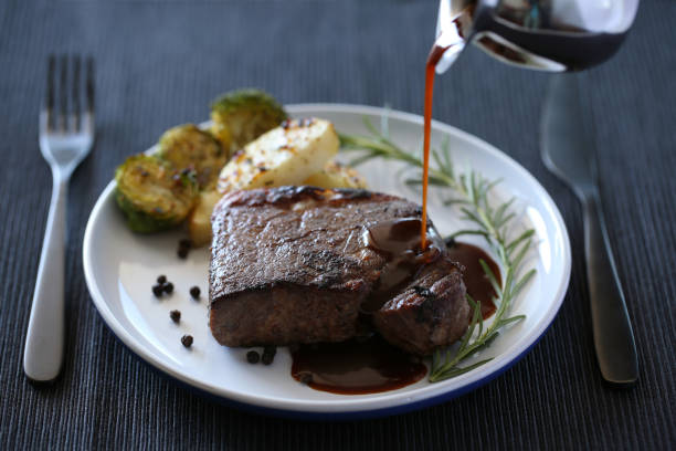 istock Beef steak isolated on white plate with rosemary and black pepper sauce 1011094840