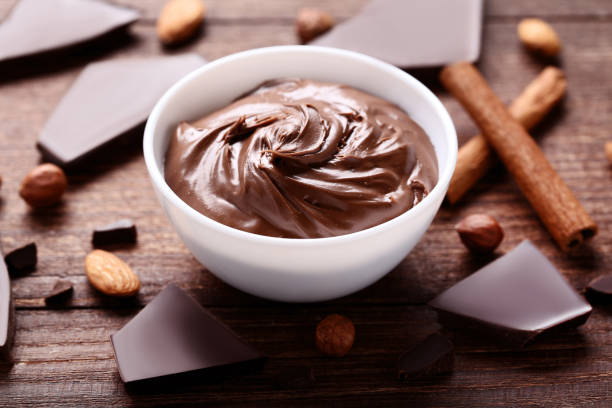 istock Melted chocolate in bowl with nuts and cinnamon on wooden table 1011113230