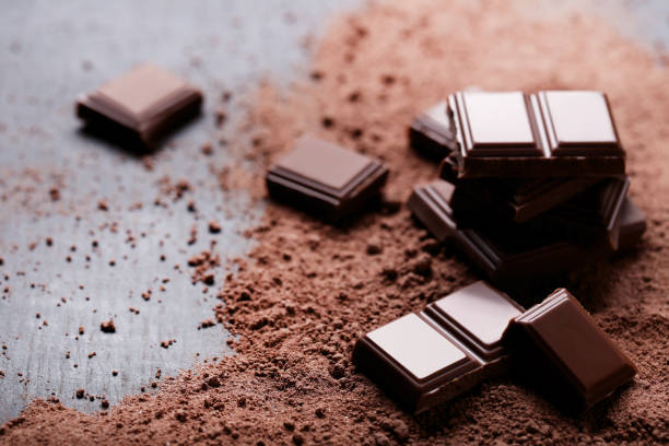 istock Chocolate pieces with cocoa powder on wooden table 1011113346