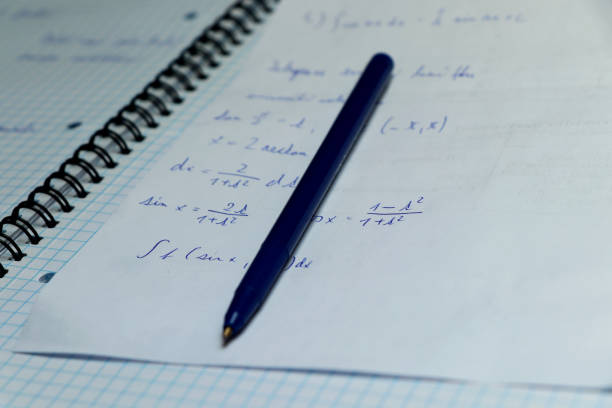 istock A exercise book for practising math in home. Blue pen with papers are casual things for studying on university 1011126092