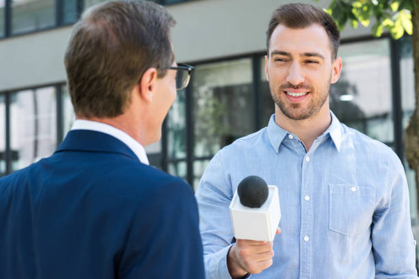 istock professional news reporter interviewing successful businessman with microphone 1011128542
