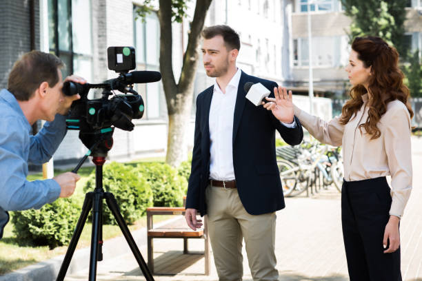 istock cameraman and professional news reporter with businessman refusing interview 1011128982